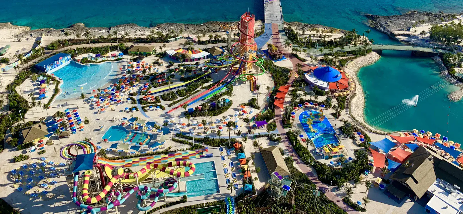 Illustrative aerial water-park photograph with colorful slides and turquoise pools