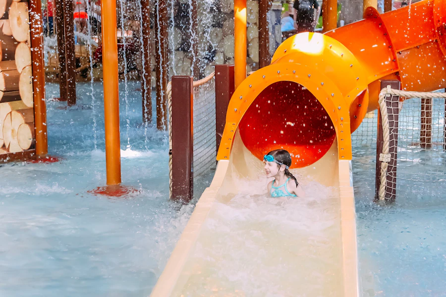 Child emerging from an orange water slide — reference photograph